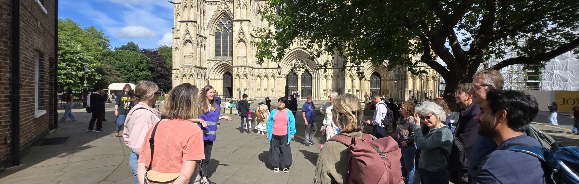 An image of a the Unconventional York Tour, with people listening to a guide as they talk about the history of Chocolate in the city.