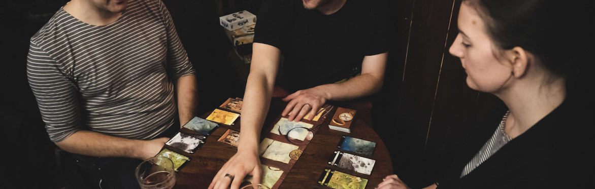 Close up shot of cards and purple wooden turnip tokens on a table from the board game "Village Pillage"