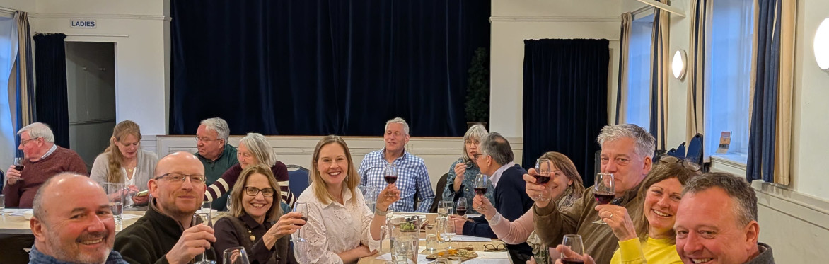 People smiling and drinking wine with each other