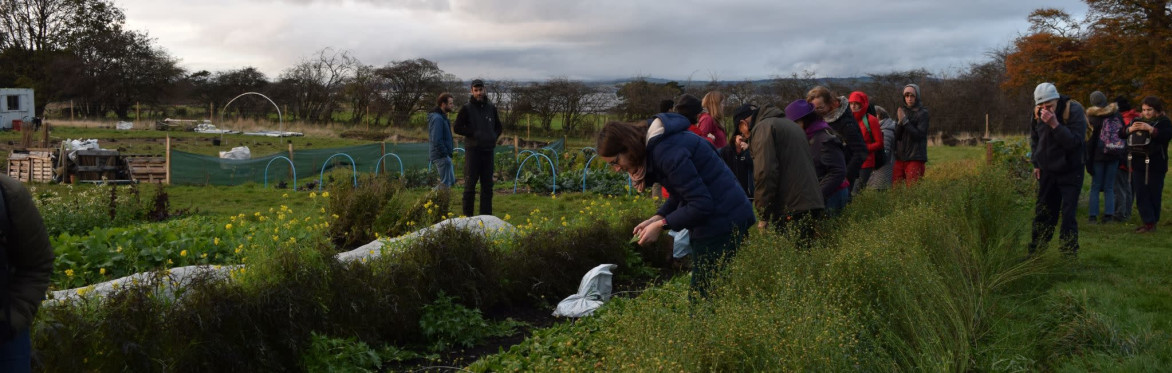 Smiling people dressed warmly and gathered in a group in the fields of Lauriston Farm