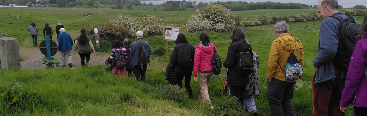 Smiling people dressed warmly and gathered in a group in the fields of Lauriston Farm