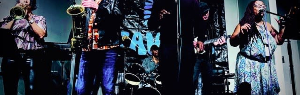 Kiziah and the Kings, a 6 piece band, stood on steps in a stairwell,  not smiling