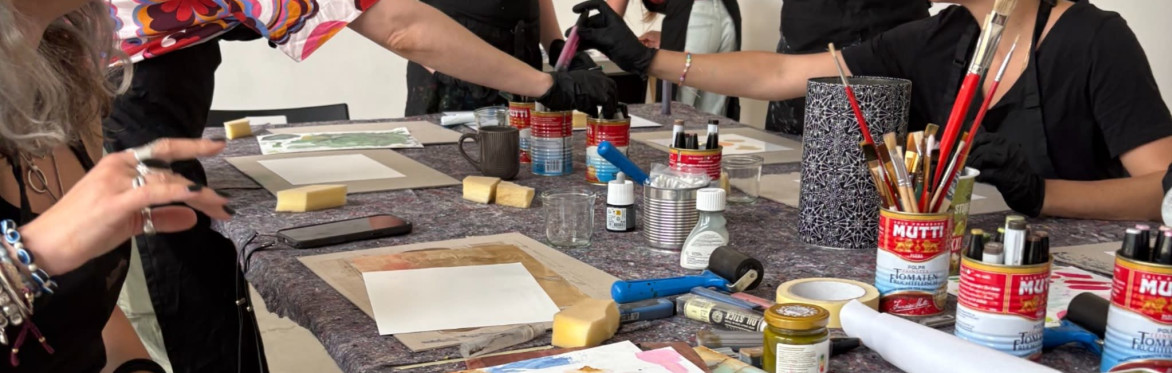Two participants creating colorful alcohol ink artworks in a bright artist studio.