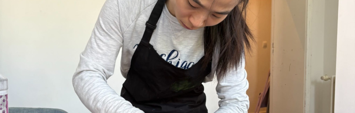 Two participants creating colorful alcohol ink artworks in a bright artist studio.