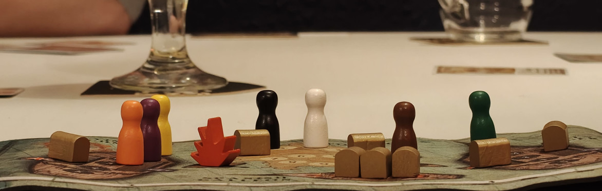 Close up shot of cards and purple wooden turnip tokens on a table from the board game "Village Pillage"