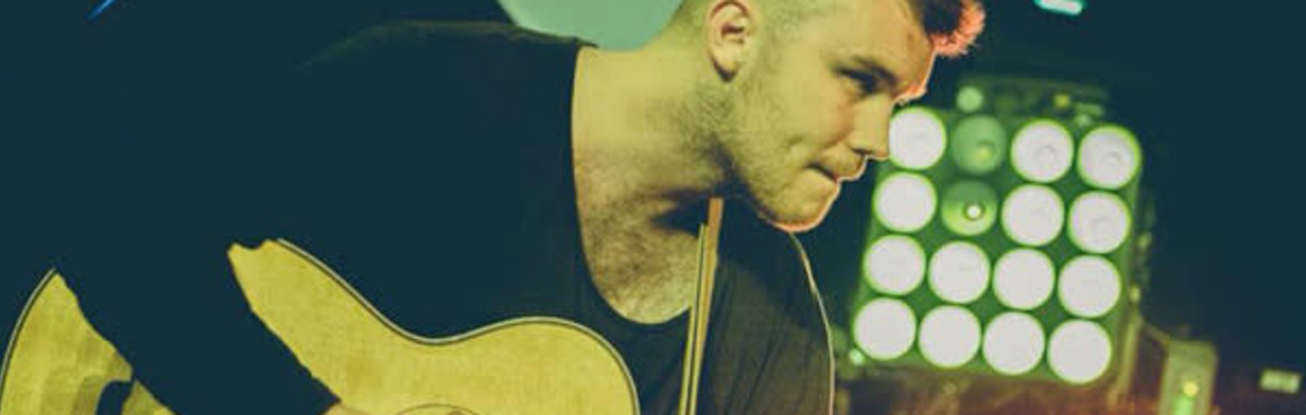 Sam looking down on his guitar onstage