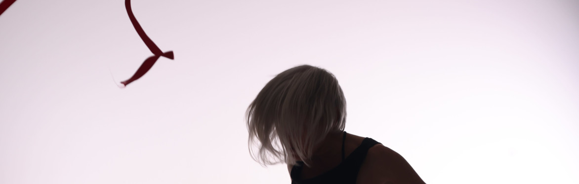 Dancer dressed in black, reaching to left