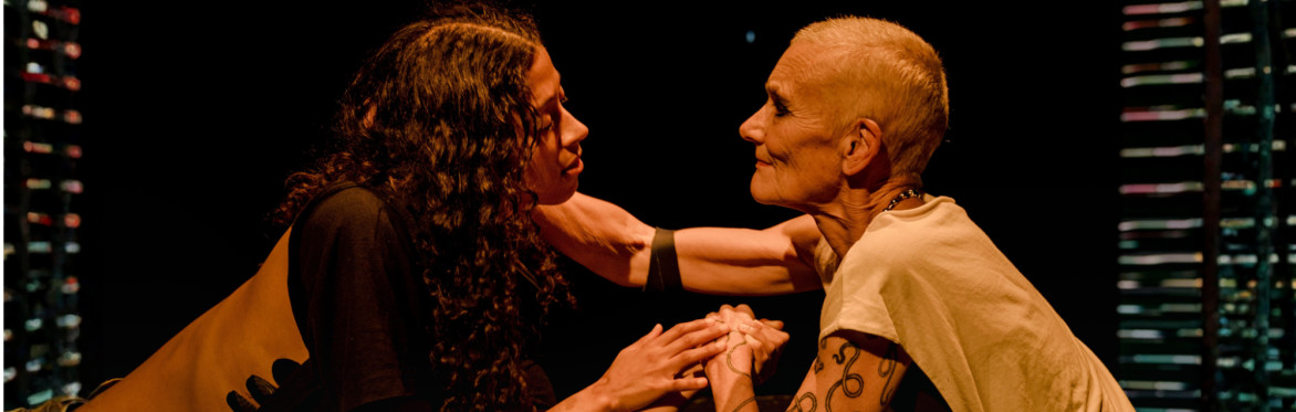 two performers in a partial embrace
