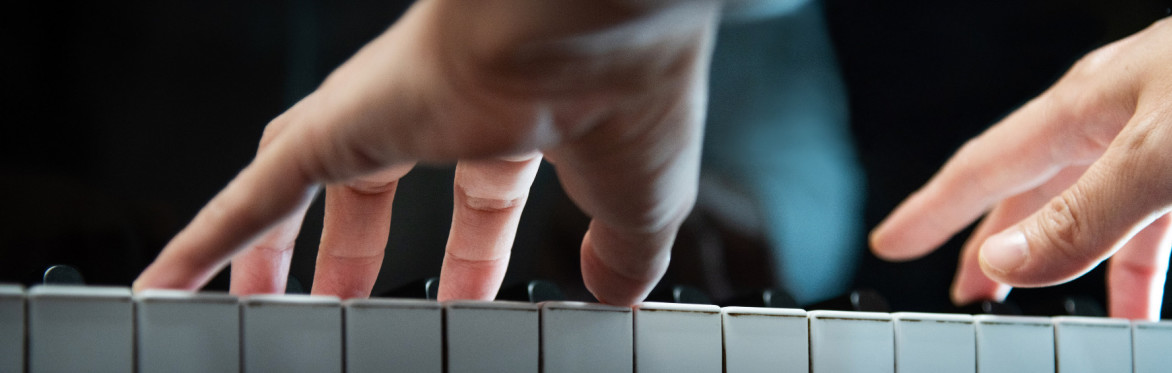 a person's hands playing piano
