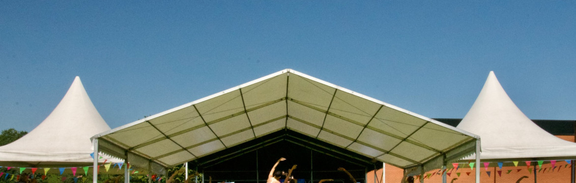 The image shows a group of people taking part in the powerhoop workout class outside at the festival from 2025.
