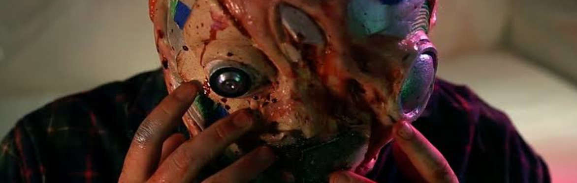 A distorted multi-coloured alien seeming face