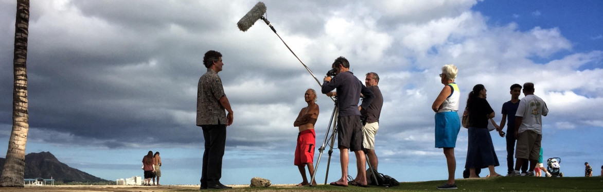 A TV News crew interview a man in front of stormy skies. Hawaii floods 2017. Photo credit: paulsmaldone/StockimoNews/Alamy Live News