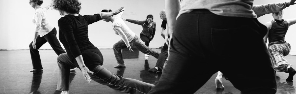 black and white photo of dancers in a studio stretching