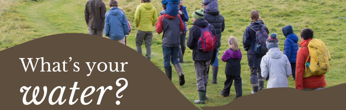 A background photograph of people walking over grass towards a river. White text reads 'What's your home water?'