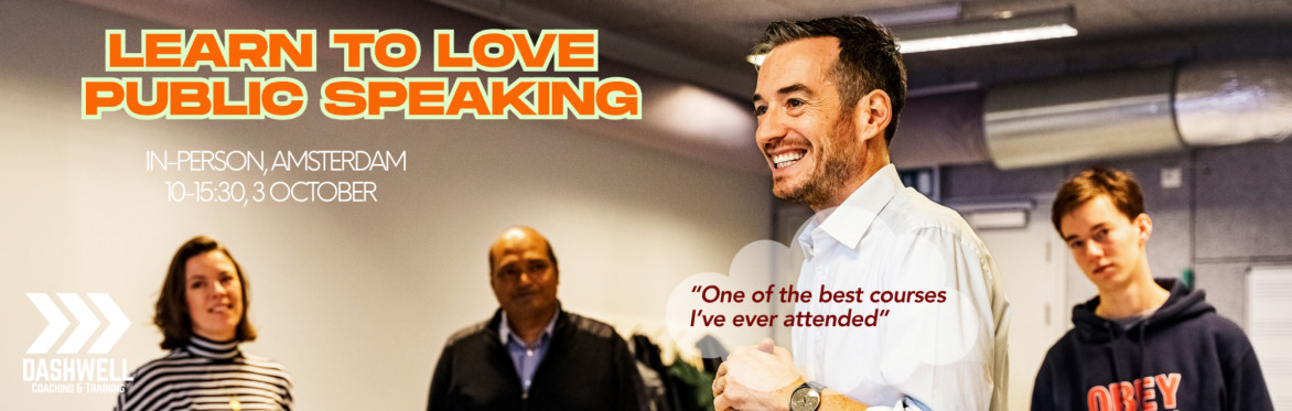 A smiling man speaks to a group