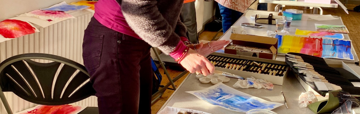 people painting on tables in an art class