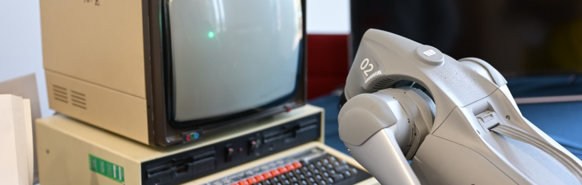 robot leaning over 1960s computer