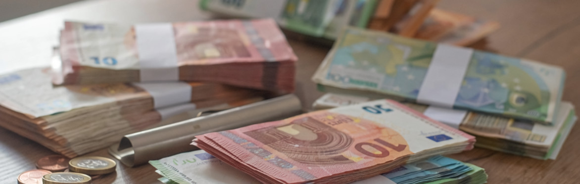 Small bundles of euro notes and coins.
