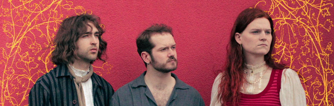 The members of Craven are standing next to each other, looking to the right, in front of a red background with gold ornamentation drawn behind them.