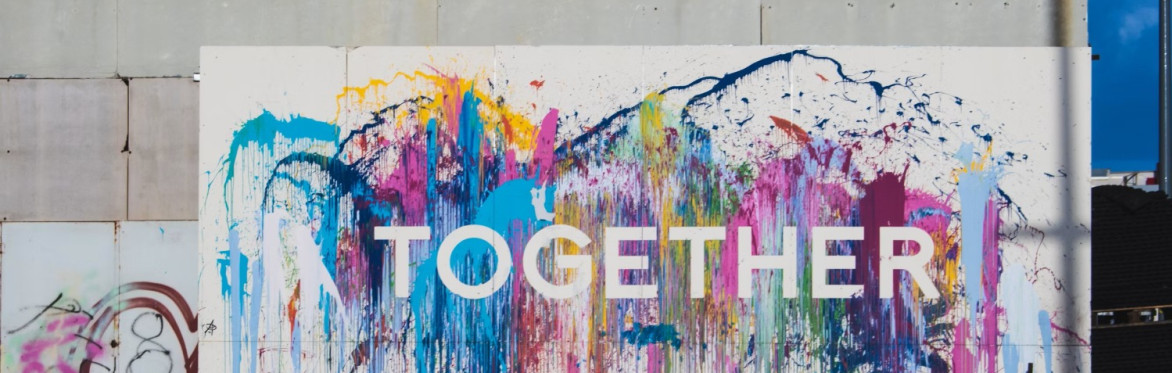 A white wall with a large white painted piece of paper with the word 'together'.