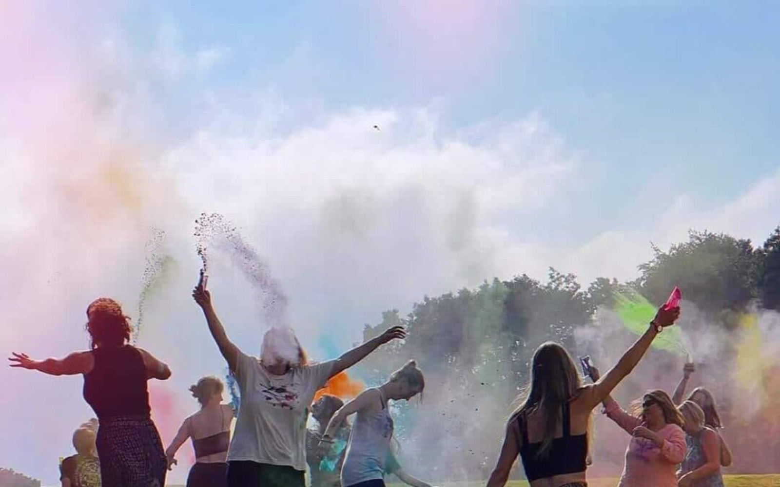 Festival goers celebrating outdoors with colourful powder.