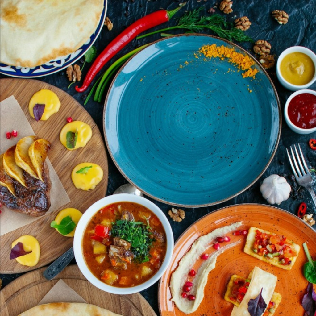 A wooden table spread with wings, noodles, dumplings, rice, and fries — a warm, homemade-style mix of dThis is an artist rendition of the mosaic art piece that would be placed at Prospect on Cortland.