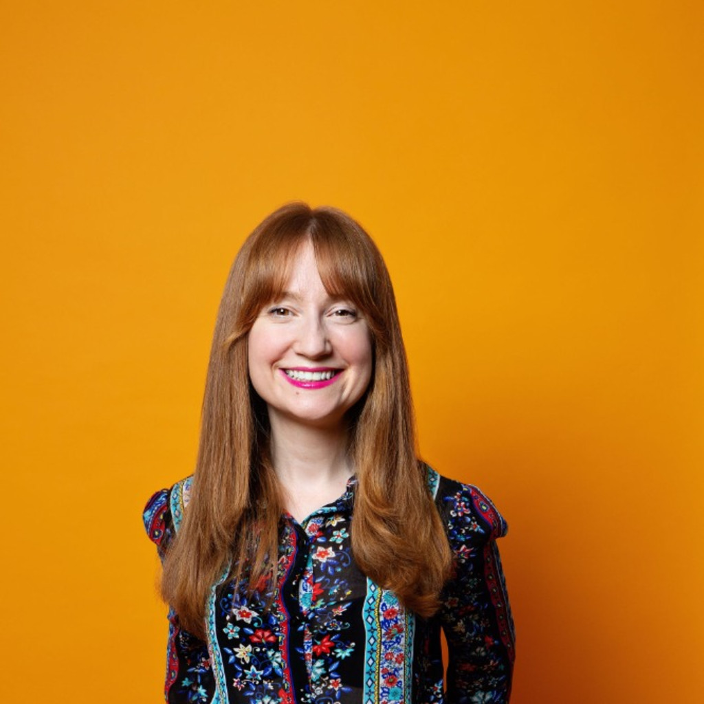 Woman with ginger hair smiles at the camera