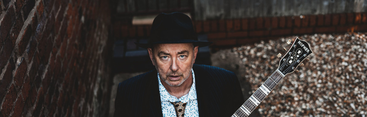 Francis Dunnery dressed smartly with a Hofner Guitar