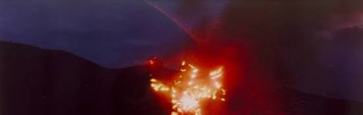 a still from an ana mendieta flim, showing an outline of a body made with red flares