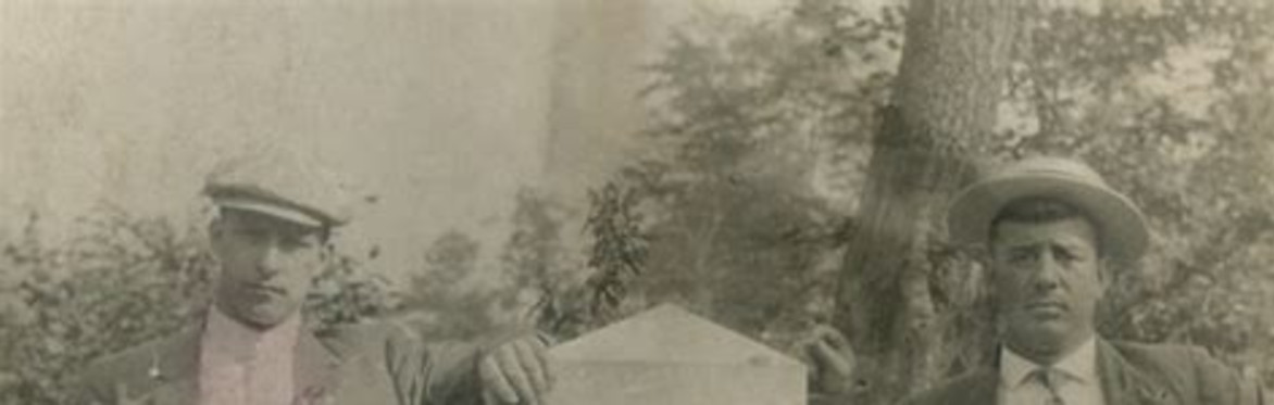Monument to the lost children of the alleghenies with two men standing next to it
