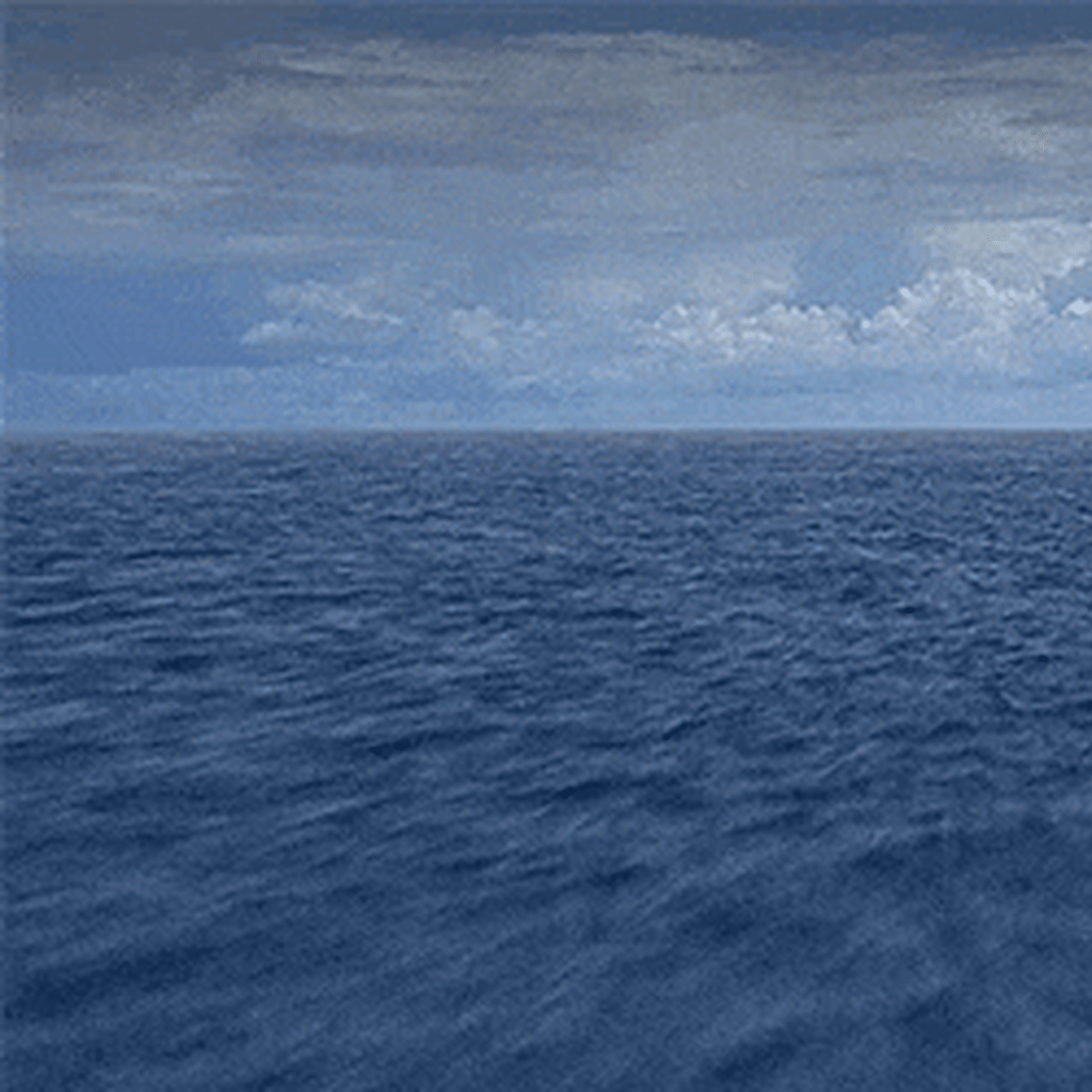 A flyover of the ocean with a cloudy sky above