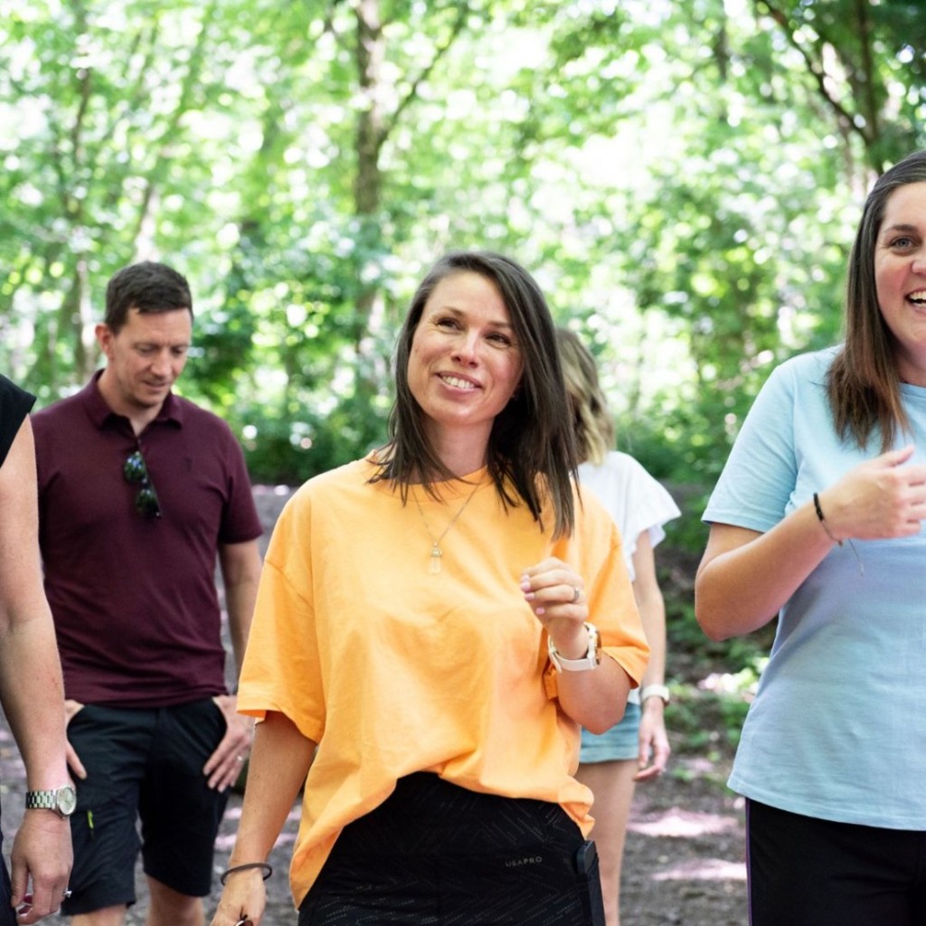 People walking through the forest smiling