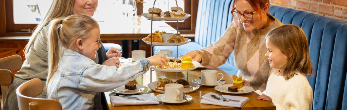 A family in front of an afternoon tea stand