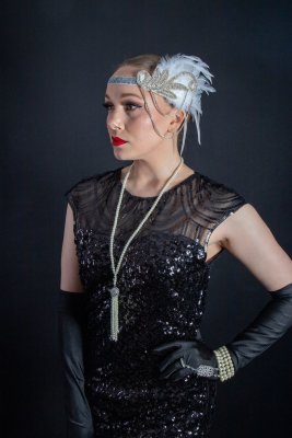 Headpiece with white feather, rhinestones and beautiful chains on the side.