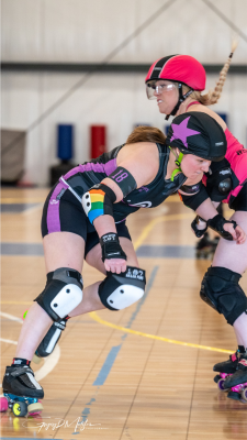 A2 Roller derby jammer skating around her opponent.