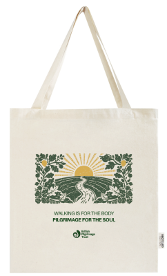 tote bag with yellow sunrise behind a green hill