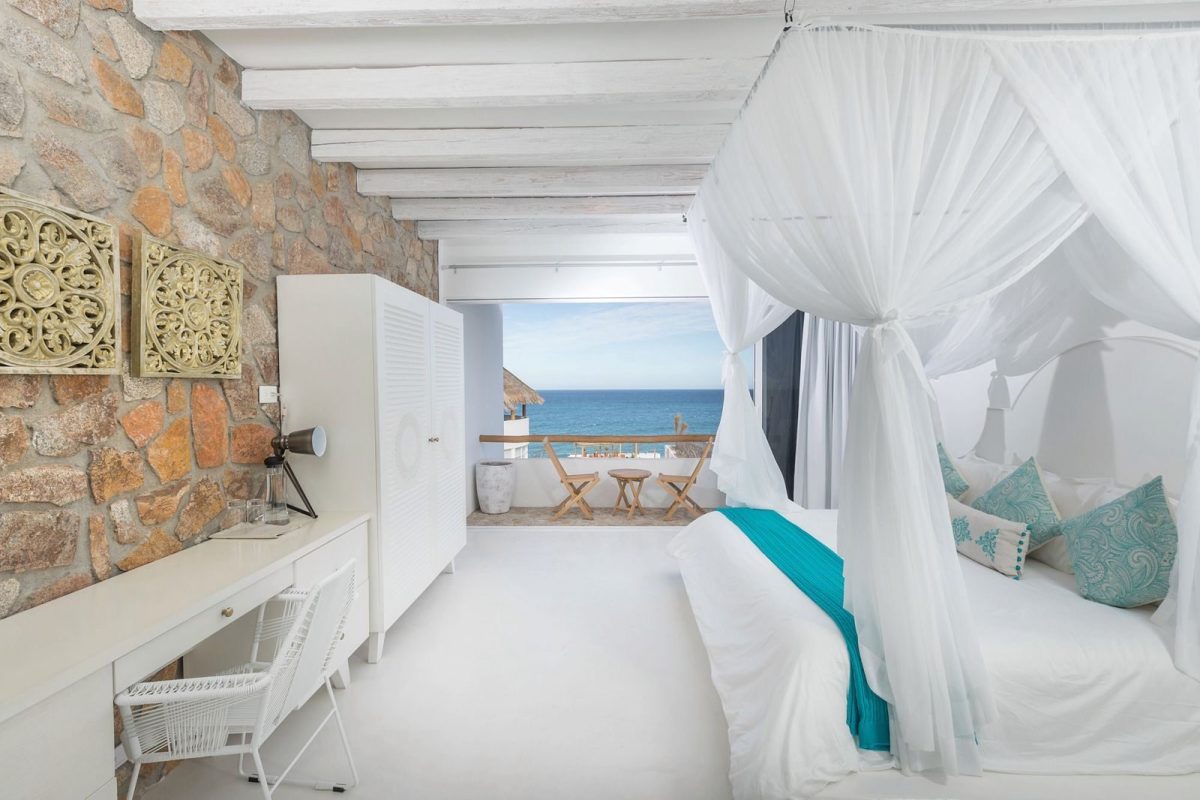 A double room with a stone wall and a view of the sea