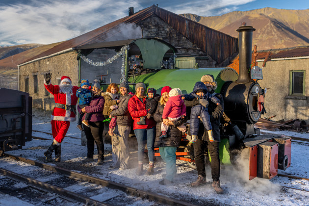 Happy adults and children in front of a steam locomotive