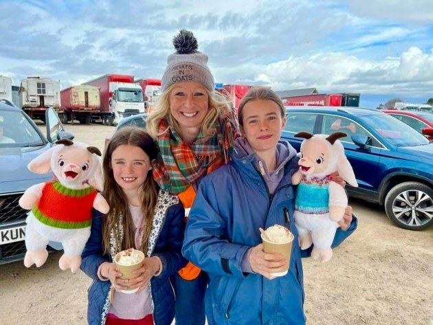 Two young girls and a Goats in Coat staff member showing off their new Goats in Coats teddies whilst drinking hot chocolate