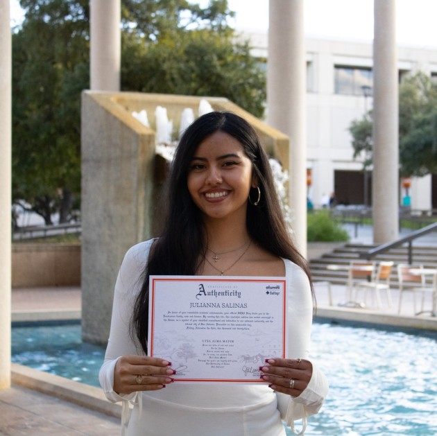 ring recipient in front of the Sombrilla Fountain with Ring Certificate