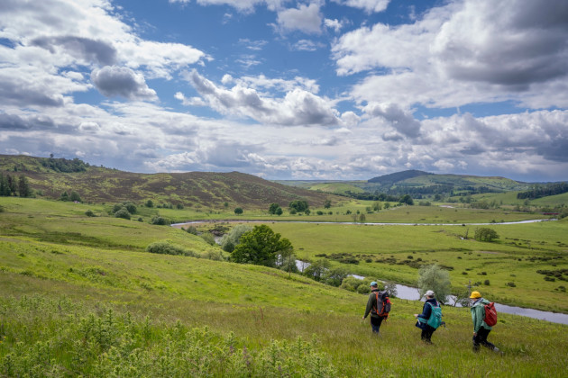 People walking through a green valley