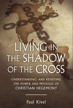 Book cover of Living in the Shadow of the Cross by Paul Kivel. Old map of the Americas under the shadow of a cross-shaped chain.