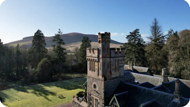 Aerial view of Wiston Lodge with blue sky and hills in background
