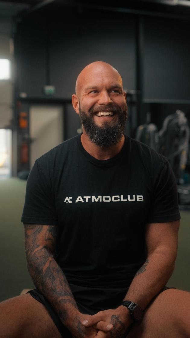 Marc, dein Coach am Tag der offenen Tür, lächelt im schwarzen ATMO-CLUB-Shirt.