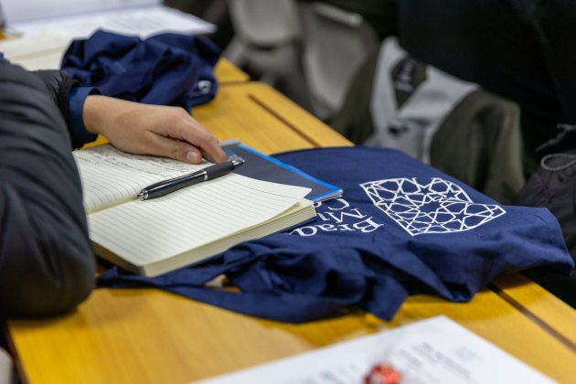Study notes and a Bradford Muslim College bag in a classroom