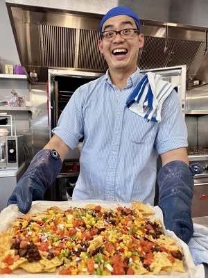 Andrew holding an amazing pan of nachos