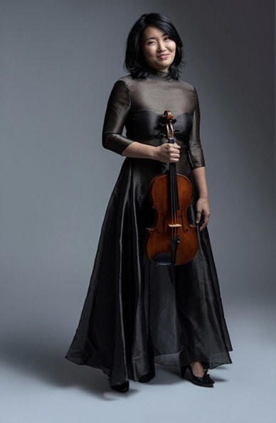 Clara holding a viola, wearing a black dress.