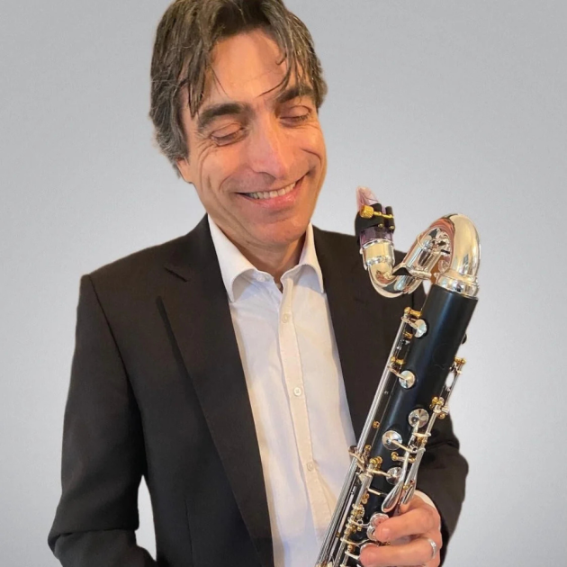 Backun artist, Paulo De Gaspari smiles and holds a bass clarinet
